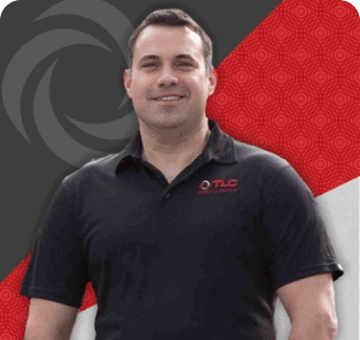 A man wearing a black TLC Outdoor Living polo shirt stands in front of a background with black and red geometric patterns, representing the quality and expertise of TLC Drain.