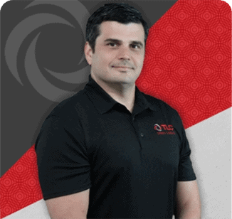 A man in a black polo shirt stands in front of a geometric red, gray, and white background with a circular TLC Drain logo in the top left corner.